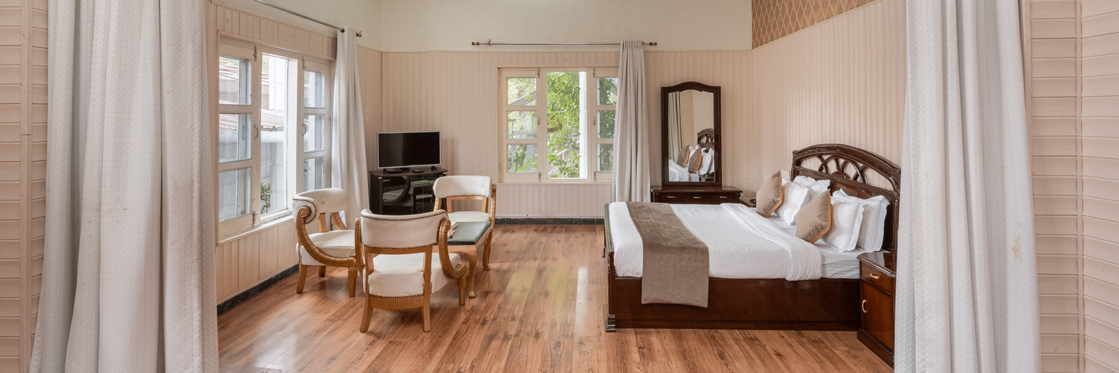 Luxurious suite featuring a bedroom and a living area at DLS Tehri Club Resort.